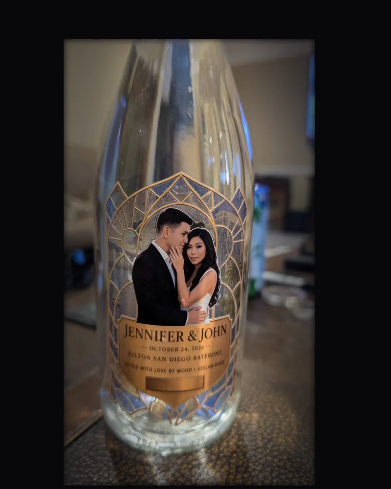 A clear bottle with a custom stained-glass style wedding label