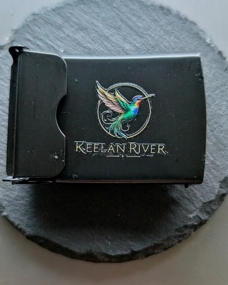 Black belt buckle with the Keelan River hummingbird mark